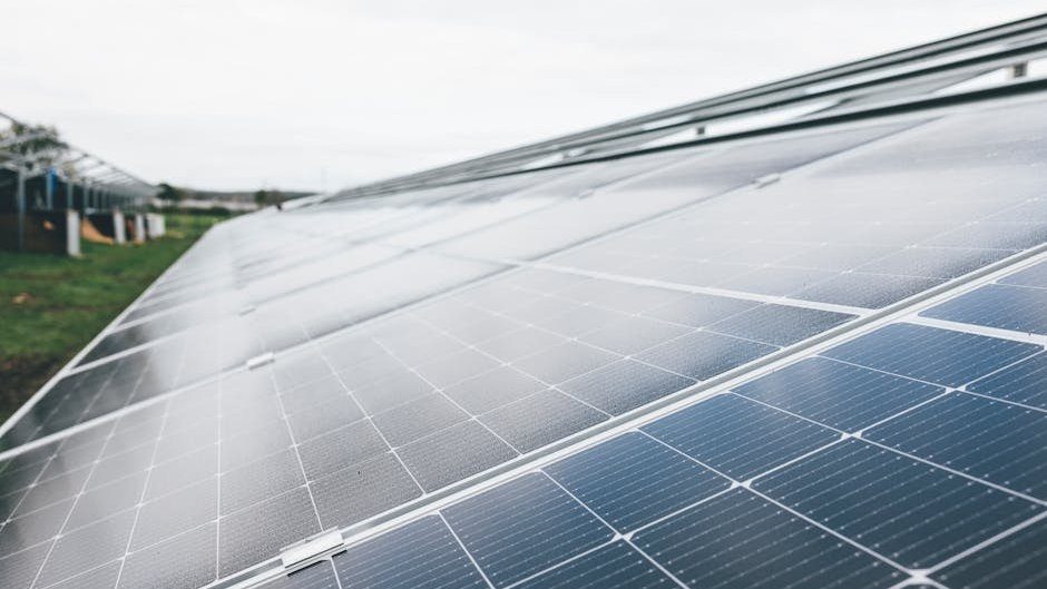 Detailed close-up shot of solar panels at an outdoor solar farm under clear sky.